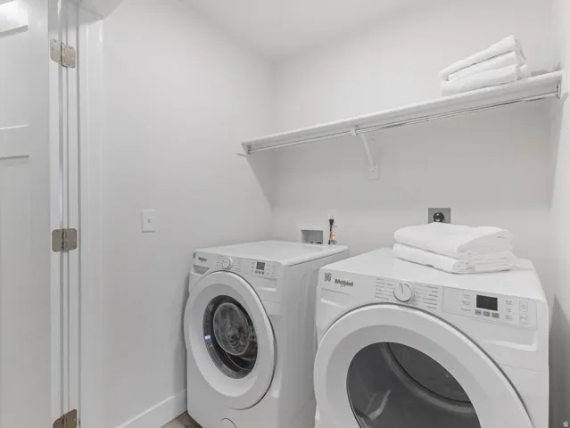 Dedicated laundry area featuring a white shelf with hanging rod