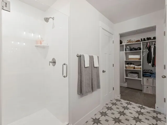 Walk-in shower with clear glass enclosure and brushed nickel fixtures