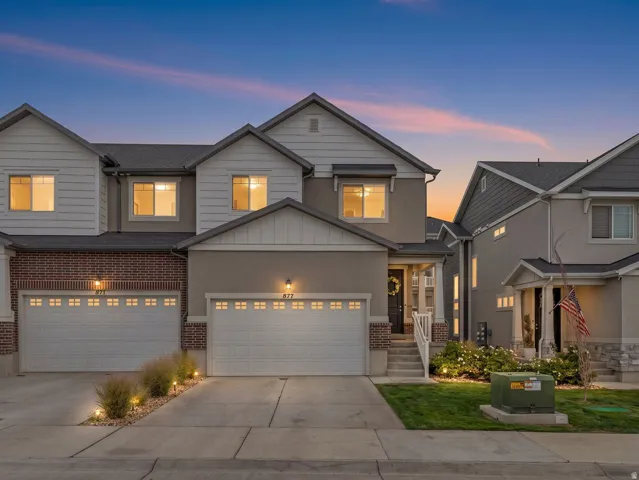 Contemporary exterior featuring a stucco and brick facade, white siding accents, and a two-car garage