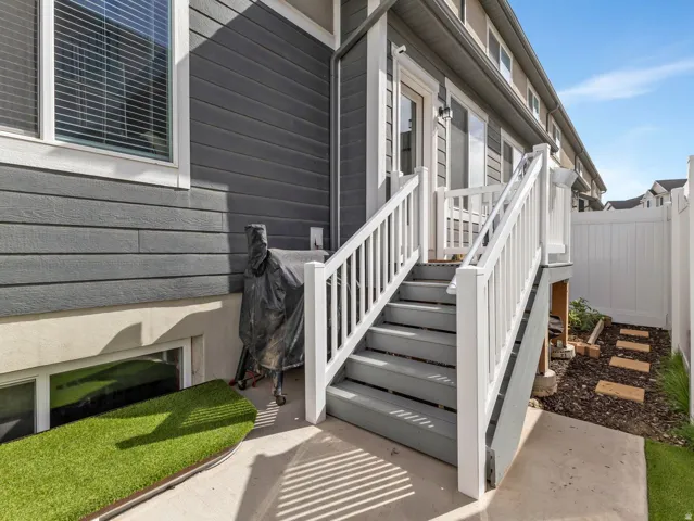 Exterior featuring horizontal siding, white trim, a concrete patio, and a white privacy fence
