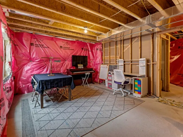 Unfinished basement space featuring exposed wood joists and structural framing