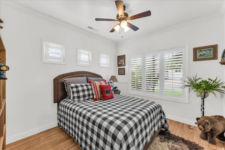 Hardwood-style flooring with white walls and crown molding