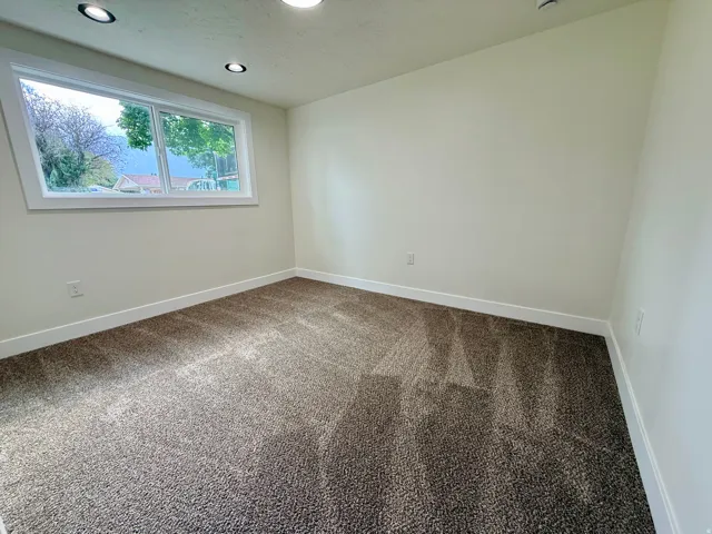 Recessed lighting, neutral wall paint, white trim, and carpeted flooring