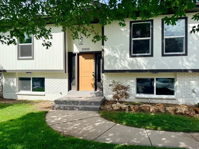 White painted brick and siding exterior with dark trim accents