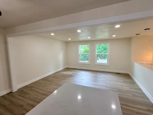 Spacious interior featuring wood-finish flooring, recessed lighting, and a white countertop