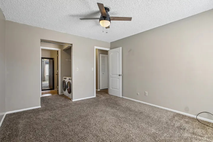 Carpeted flooring, neutral wall tones, and a ceiling fan with integrated lighting