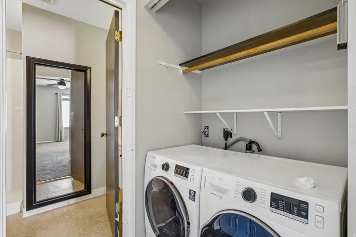 Laundry area with built-in shelving and a hanging rod