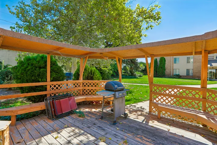 Wooden gazebo featuring built-in bench seating and lattice accents
