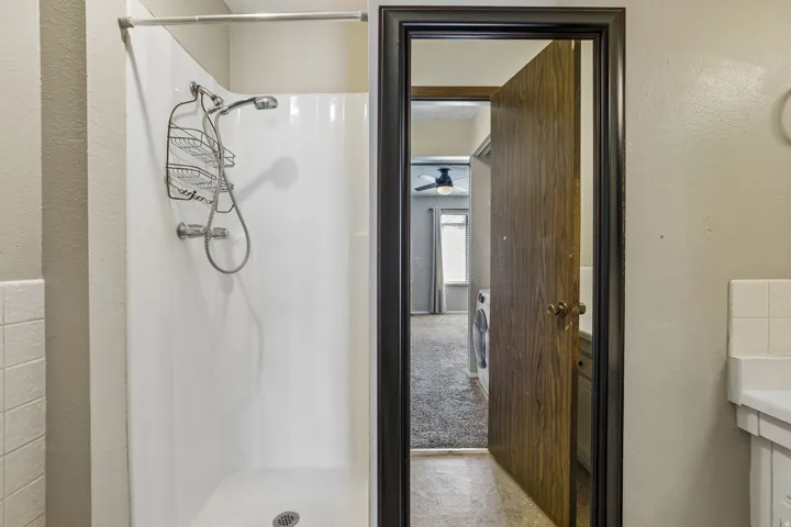 White shower surround with a handheld shower head