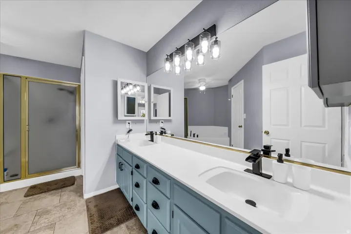 Dual vanity with integrated white sinks, matte black fixtures, and custom blue cabinetry