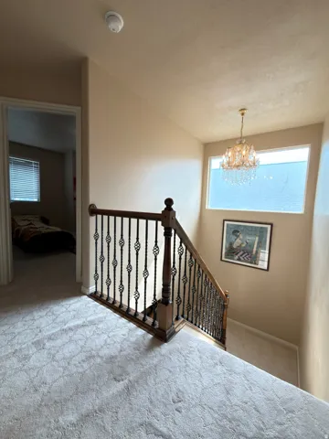 Staircase with wood newel posts, wrought iron balusters, and a wood handrail