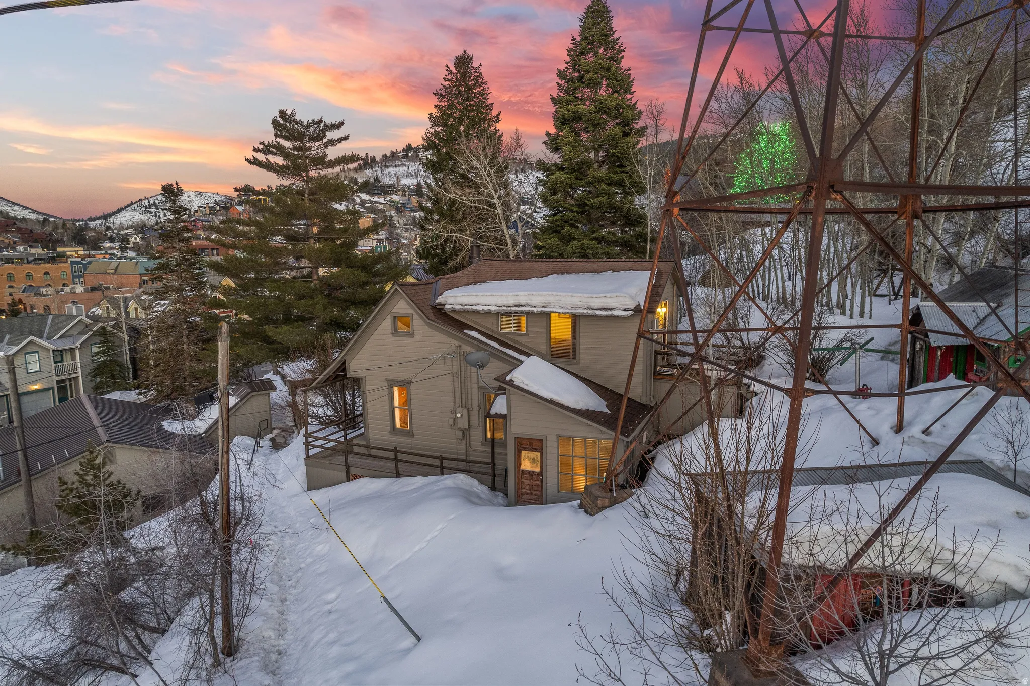Multi-story residence featuring a gabled roof and exterior lighting