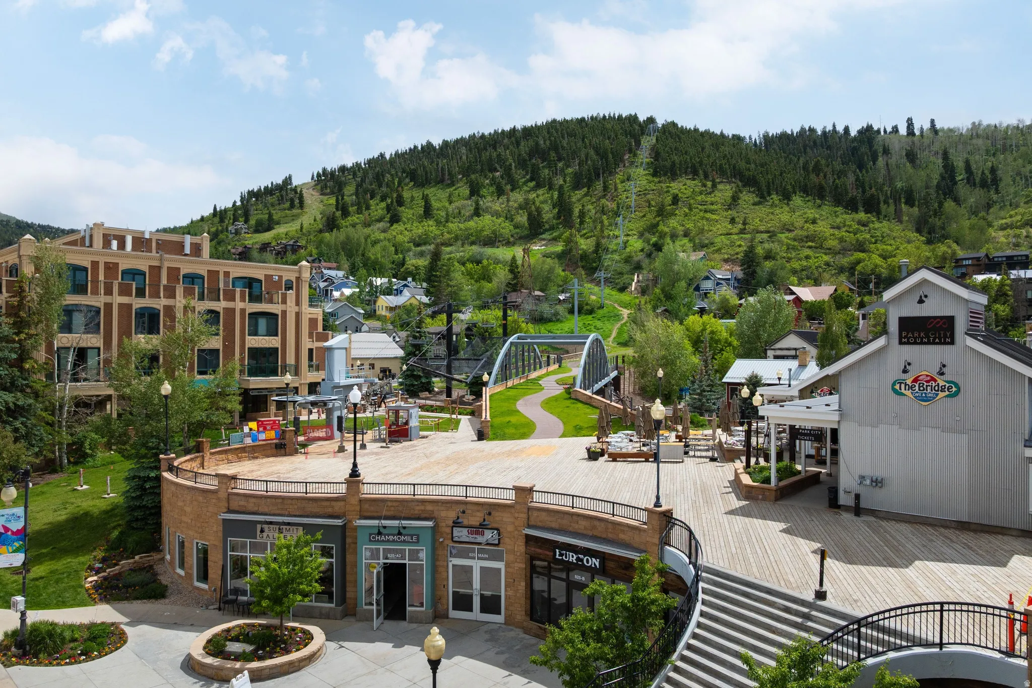 Expansive outdoor plaza featuring a multi-level design, wood-finish decking, and integrated commercial spaces