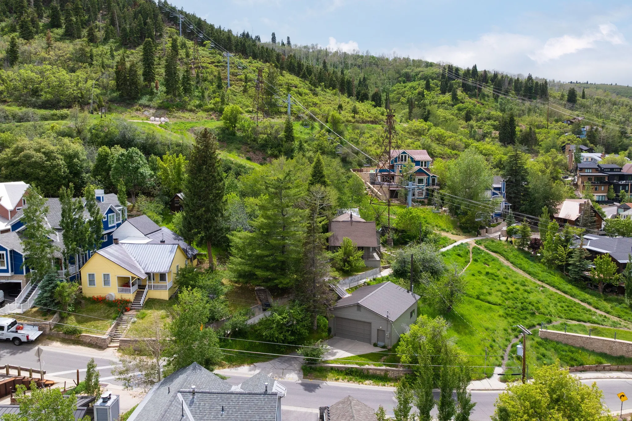 Wooded hillside setting with multiple residential structures and surrounding greenery