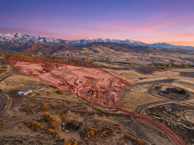 Expansive high desert property featuring a winding access road, a large building, and a main residence