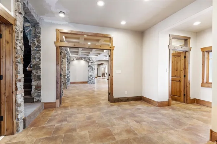 Stone-clad staircase, recessed lighting, wood-finish doors, wood-finish trim, and tiled flooring