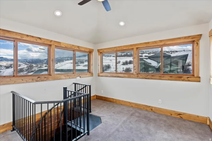 Recessed lighting, wood-trimmed windows, vaulted ceiling, ceiling fan, and carpeted flooring