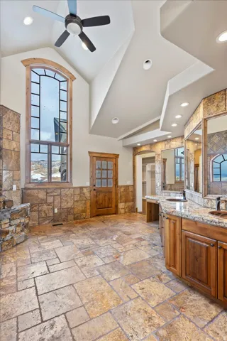 Vaulted ceiling with recessed lighting and a ceiling fan