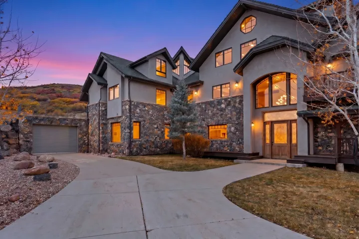 Stone and stucco exterior featuring a grand arched window entry