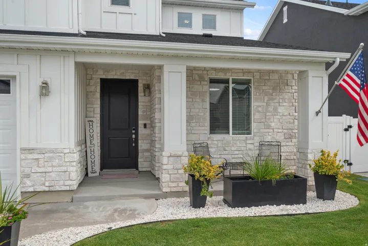 Stone veneer and board-and-batten exterior with a dark entry door