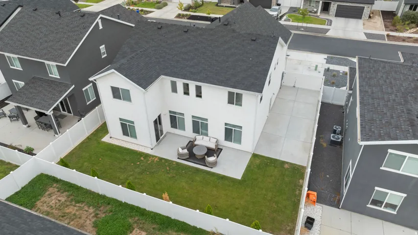 White exterior with a dark shingle roof and multiple windows