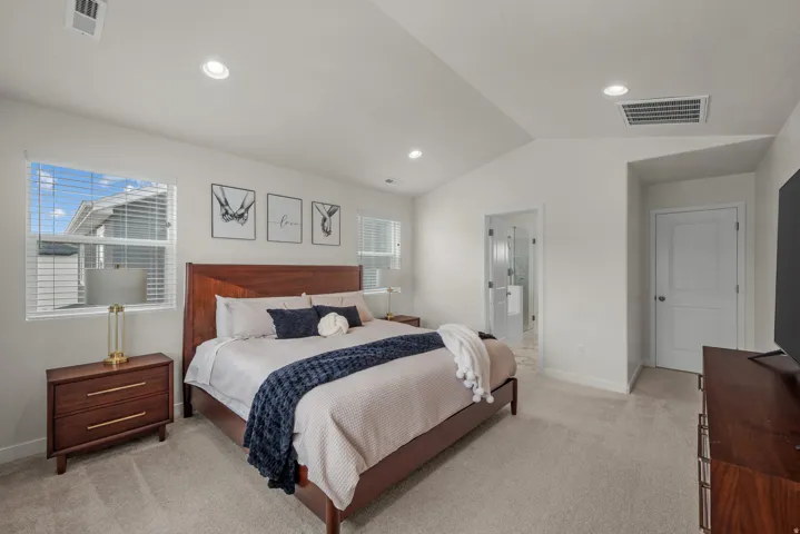 Vaulted ceilings, recessed lighting, and soft carpeting