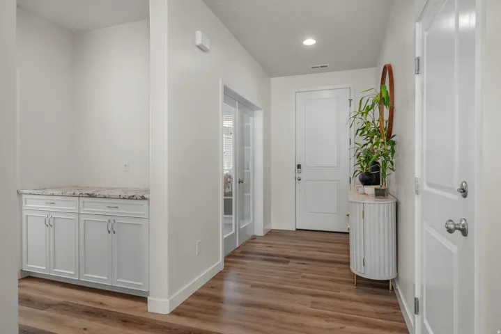 Wood-finish flooring throughout, featuring a built-in cabinet with a stone countertop