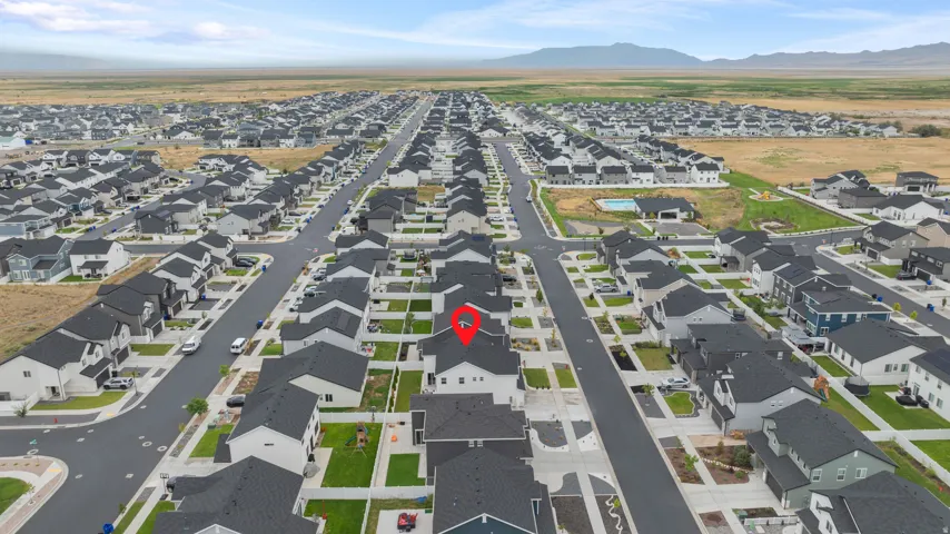 Aerial perspective showcasing a residential community with uniform home designs and dark-toned roofs