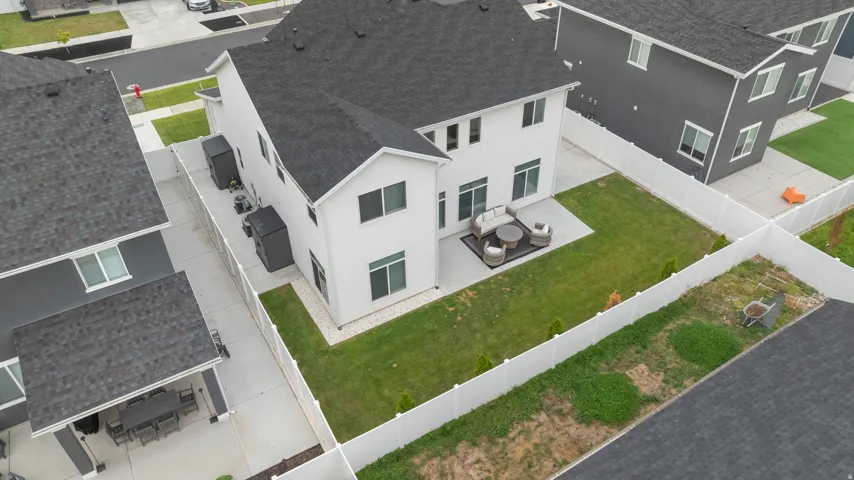 White vinyl fencing enclosing a grass lawn and concrete patio