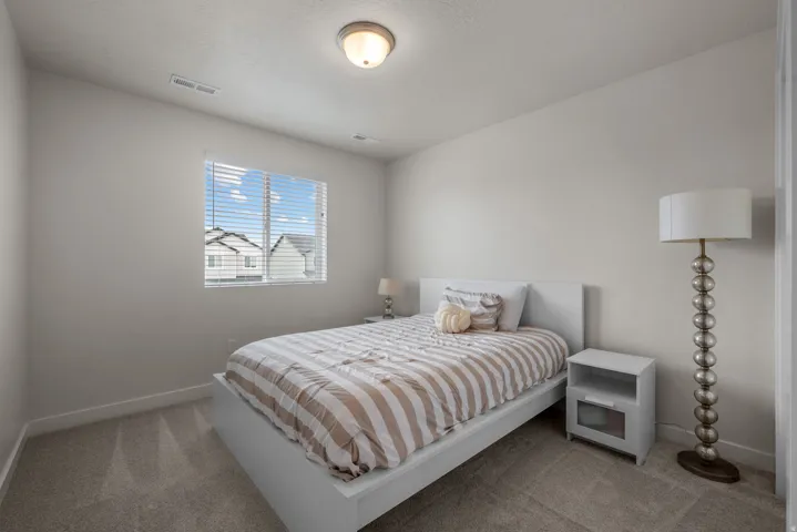 Neutral color palette, window with horizontal blinds, overhead flush mount lighting, and carpeted flooring