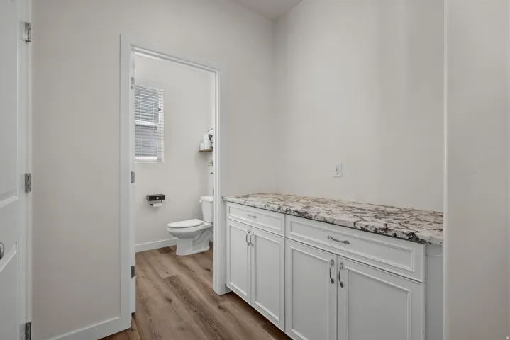 White cabinetry with polished hardware and a patterned countertop