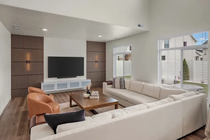 Living area featuring a vaulted ceiling, wood-finish flooring, and recessed lighting