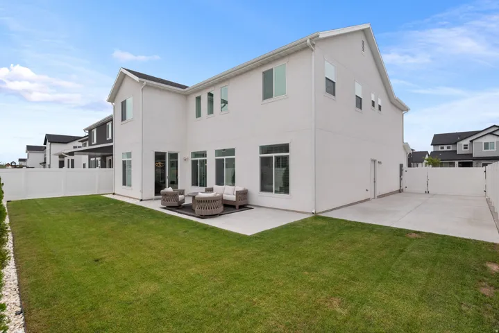 Expansive rear exterior with white stucco finish and multiple windows