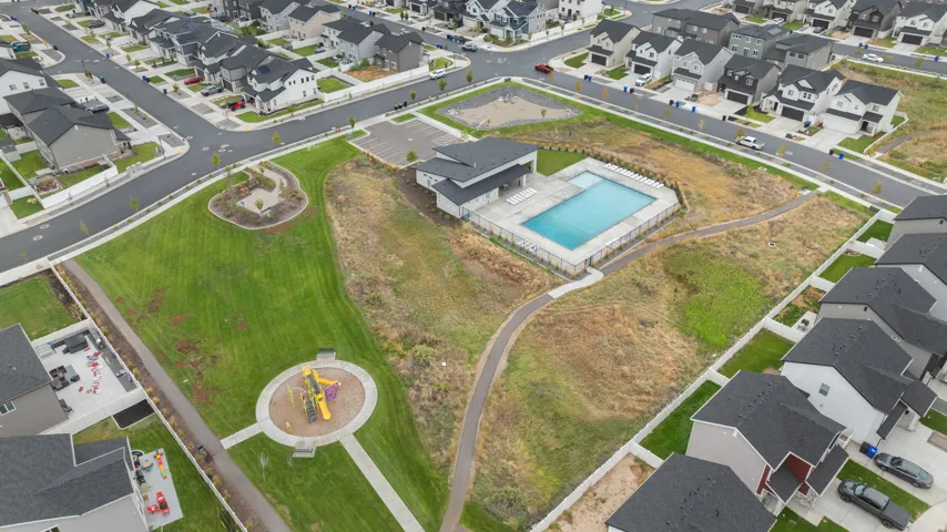 Community grounds featuring a swimming pool, a playground, paved walking paths, and expansive green spaces