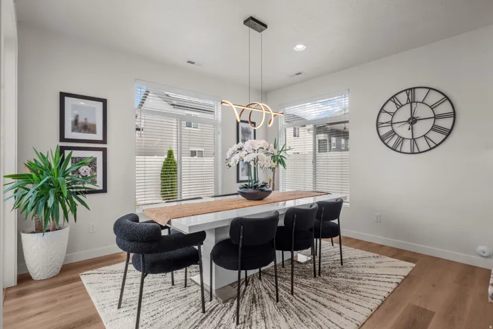 Wood-finish flooring, white walls, and a modern chandelier
