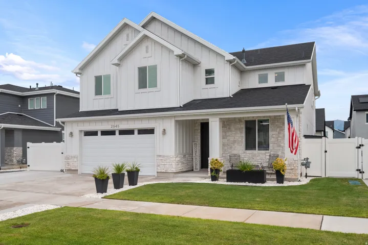 White siding exterior featuring board and batten detailing and stone accents
