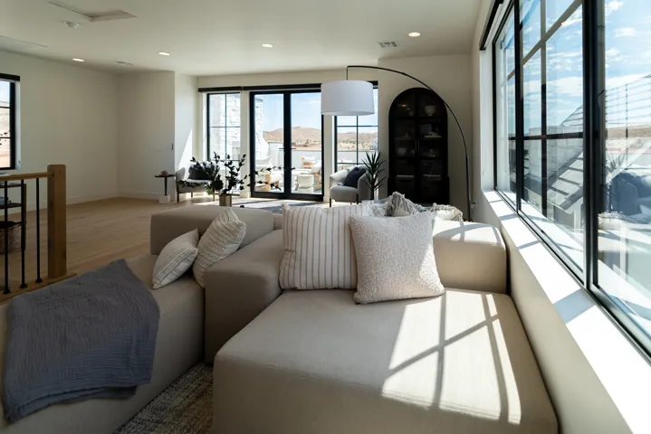 Recessed lighting, wood-finish flooring, and black-framed window and door systems