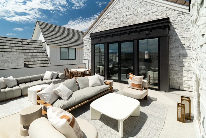 Expansive rooftop terrace with stone exterior, a full-lite sliding glass door, and an additional patio area