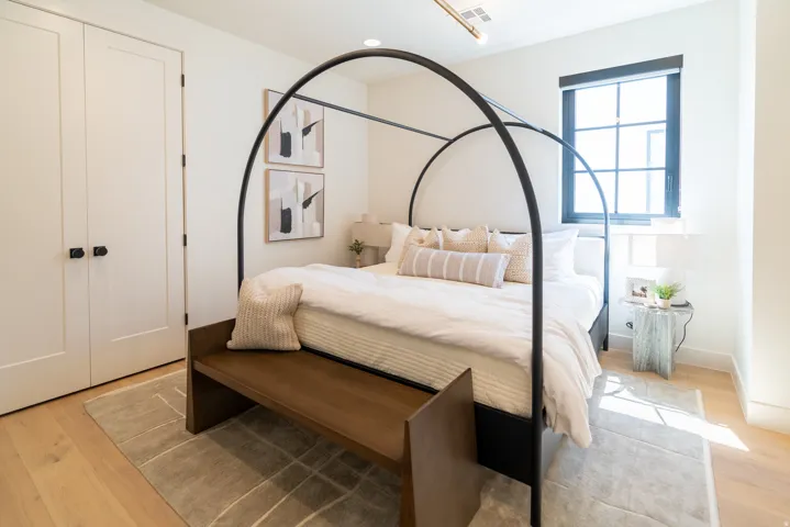 Light wood-finish flooring, white walls, and a black-framed window