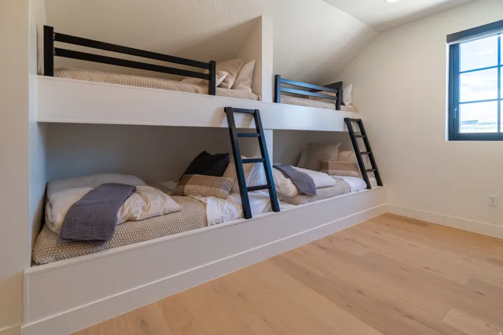 Built-in bunk beds with black railings and ladders