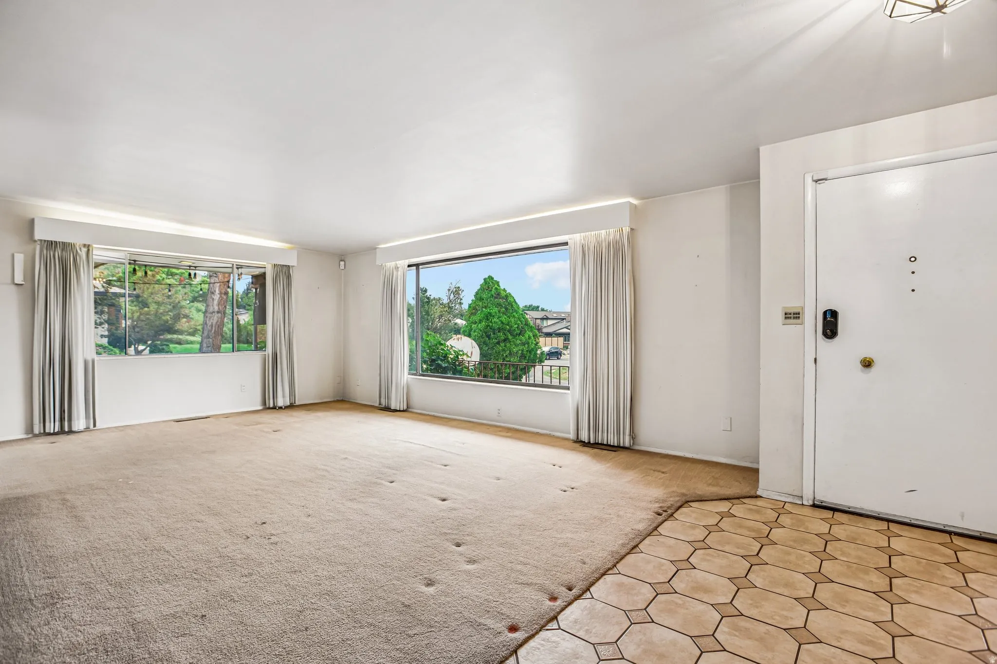 Entryway with hexagonal tile flooring opening into a room with large windows
