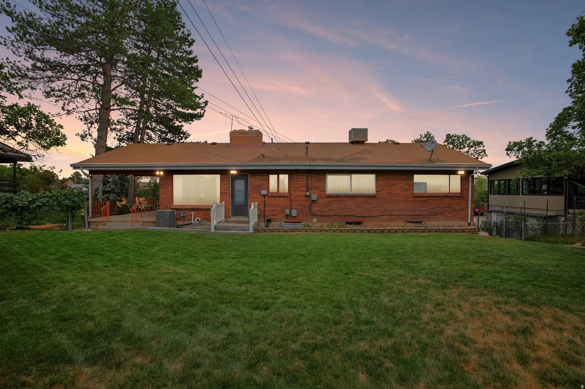 Expansive green lawn with mature trees and a brick exterior