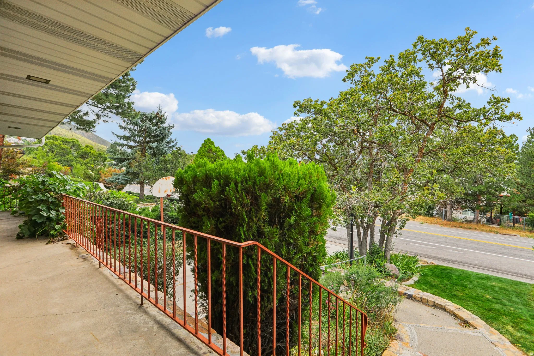 Covered porch with concrete flooring and metal railings