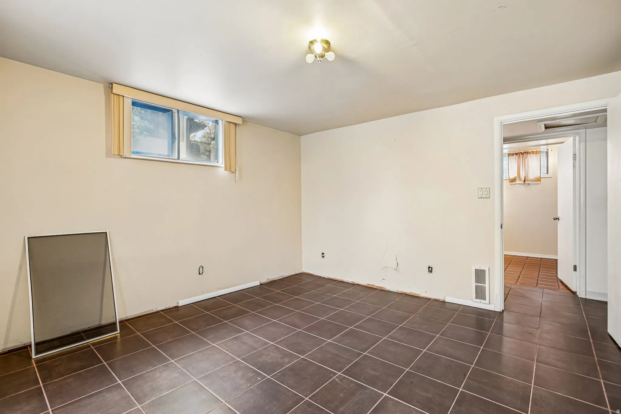 Room featuring tile flooring and a window with blinds