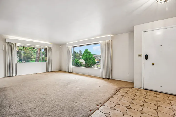Entryway with hexagonal tile flooring opening into a room with large windows