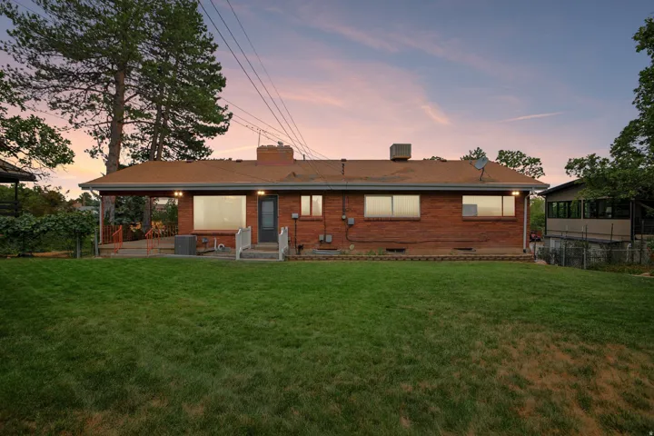 Expansive green lawn with mature trees and a brick exterior