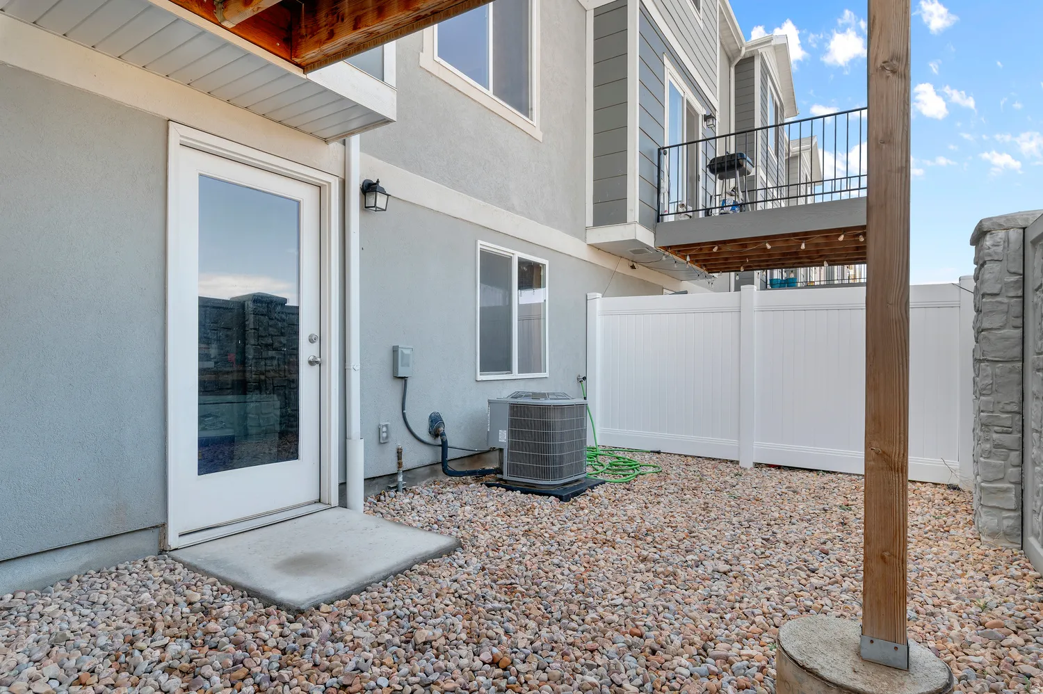 Full Daylight Walkout basement and fully fenced backyard,Gravel hardscaping, full-light exterior door, exterior wall sconce, private vinyl fencing, and a permanent wood beam. Perfect for pets.