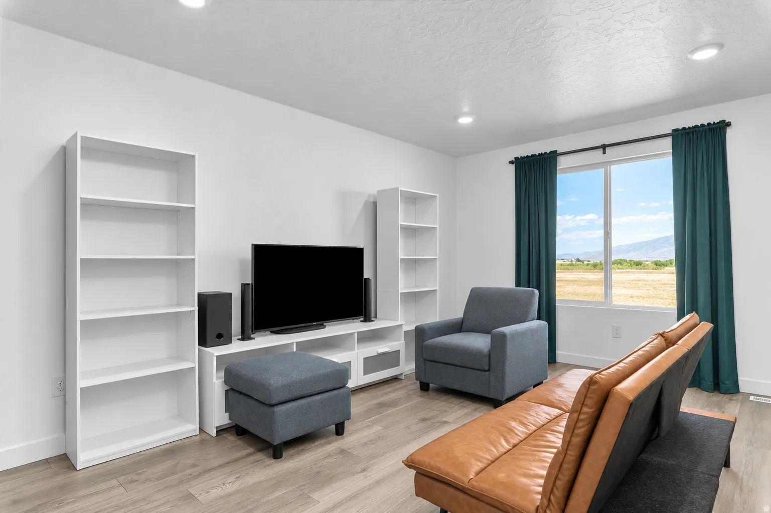 Recessed lighting, wood-finish flooring, and a large window with broad outdoor scenery