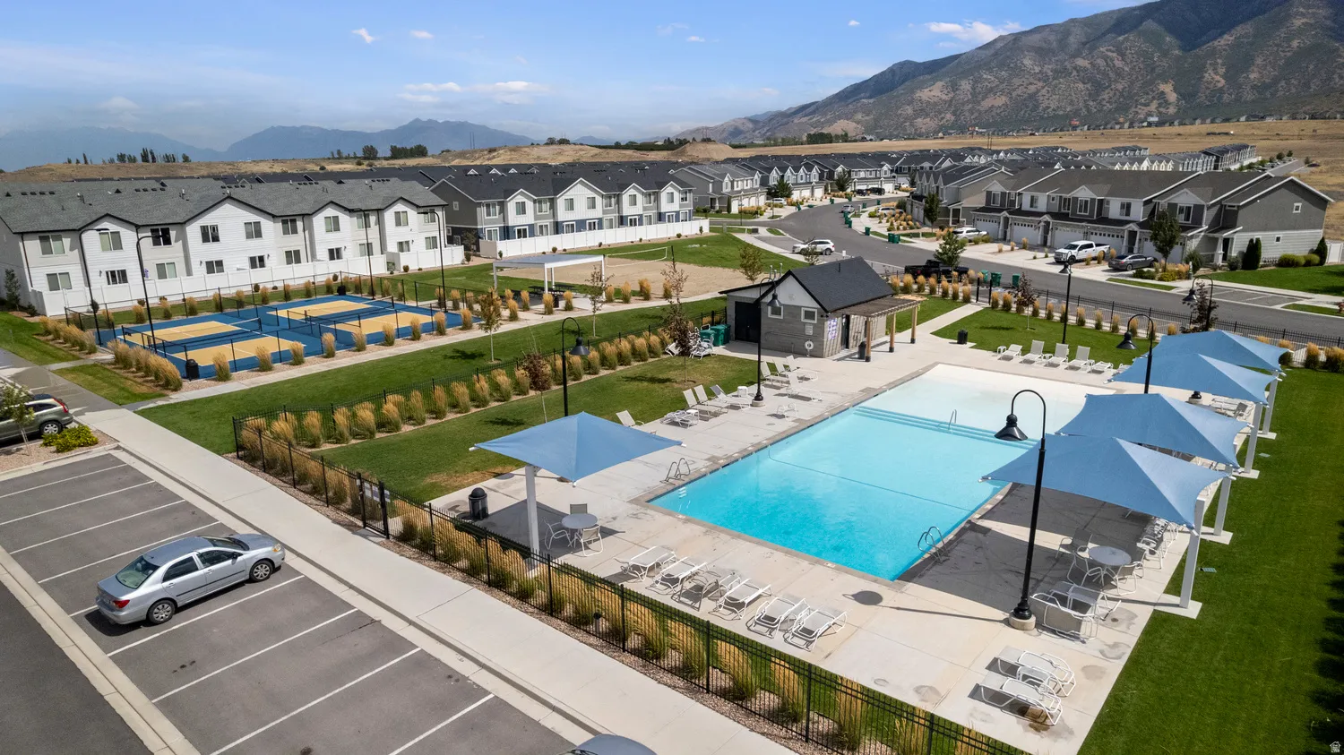 Community amenities featuring a swimming pool, multiple shade structures, and sport courts