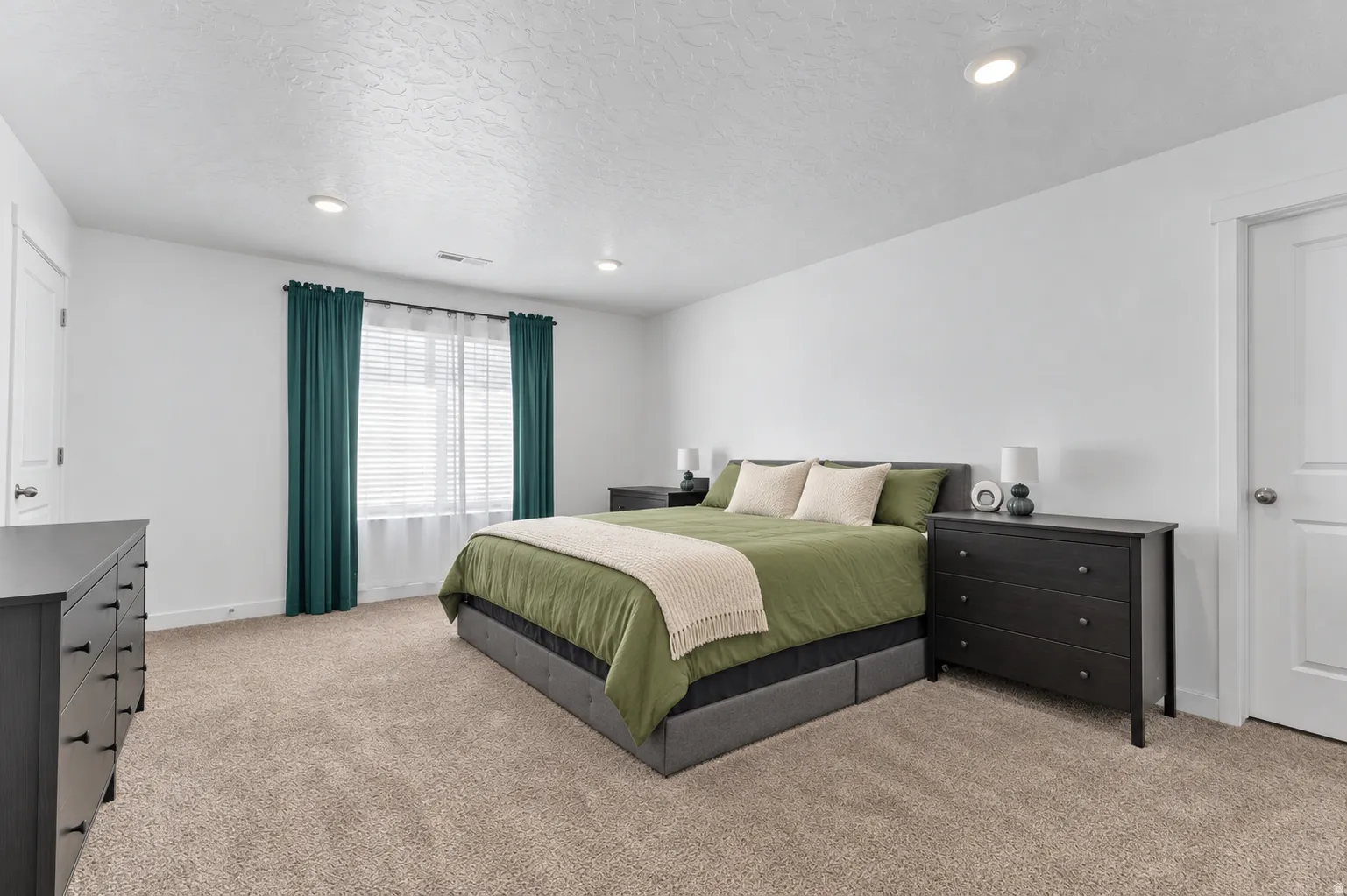 Wall-to-wall carpeting, recessed ceiling lighting, and a window with blinds